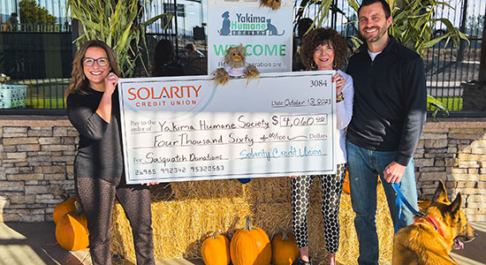 Solarity president and CEO Mina Worthington presents a check to Yakima Humane Society