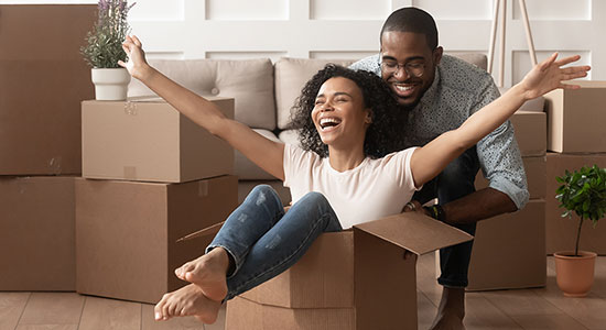 Young couple unpacking boxes in new home