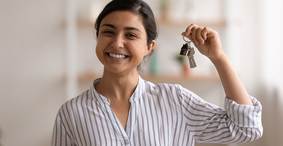 Young woman holding keys to a new house