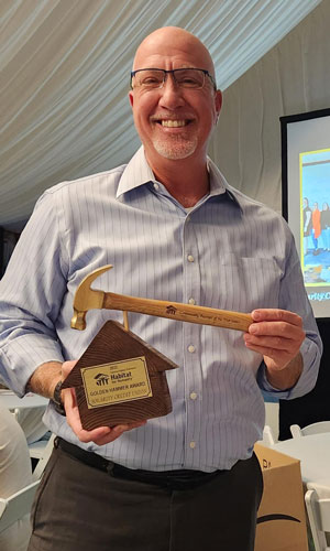 Steve Brown holding golden hammer award