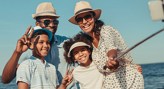 thumbnailfor Family of four taking a selfie on the beach