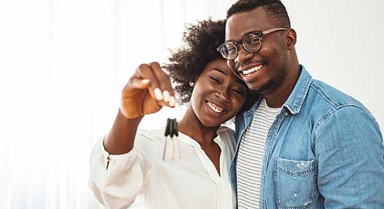 Young couple smiling after getting pre-approval for mortgage