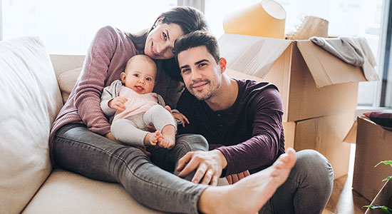 thumbnailfor Young couple sitting on the couch with their baby