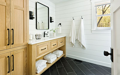 beautiful remodeled bathroom with white shiplap and black tile
