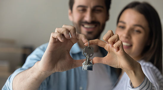 Man and woman holding keys to new house