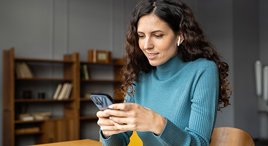 thumbnailfor Woman on home holding her cell phone