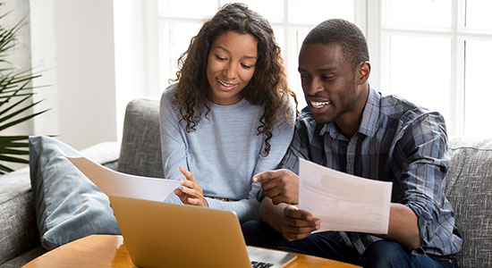 Couple sitting on couch and reviewing home loan documents