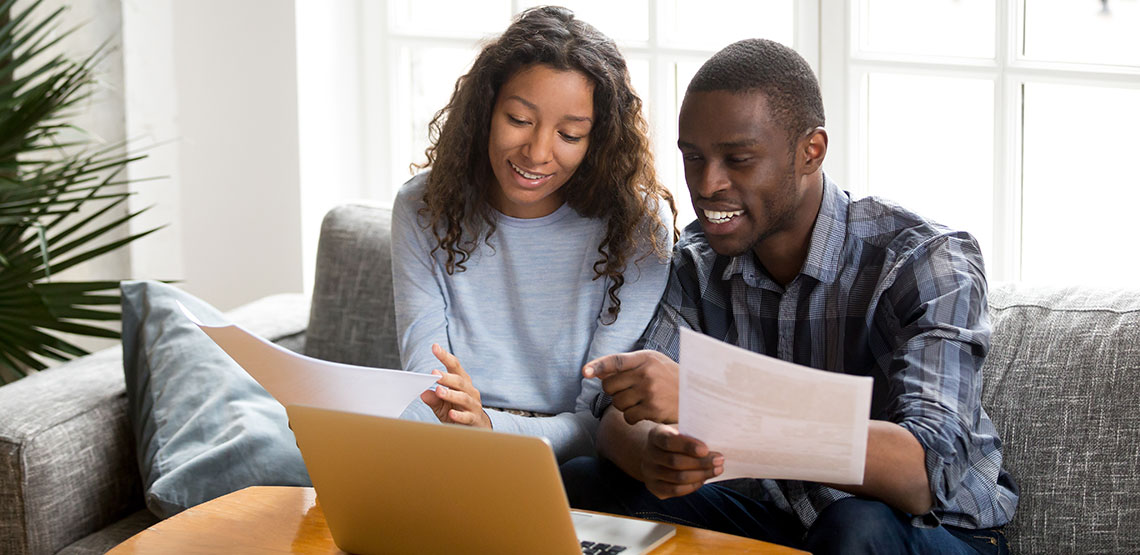 Couple sitting on the couch and reviewing home loan documents