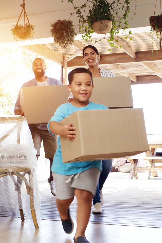Family walking into new house with moving boxes