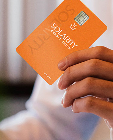 Focus of a Hand holding Solarity Credit Union Credit Card