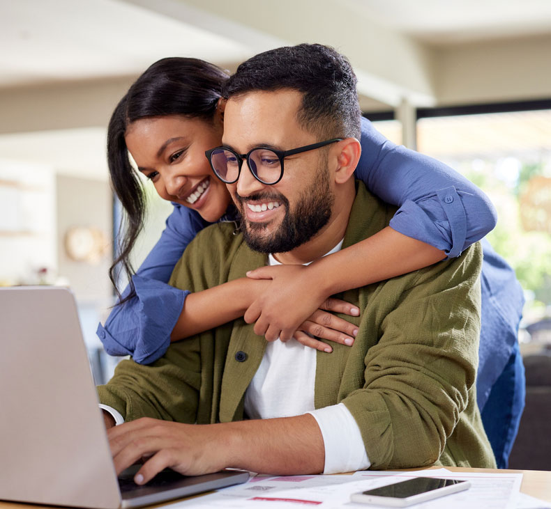 Happy couple banking on laptop