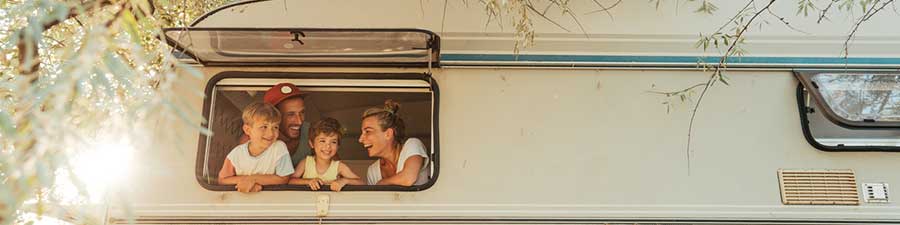 Family of four looking out the window of an RV