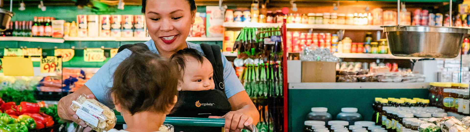 Woman shopping at the grocery store with her two young children