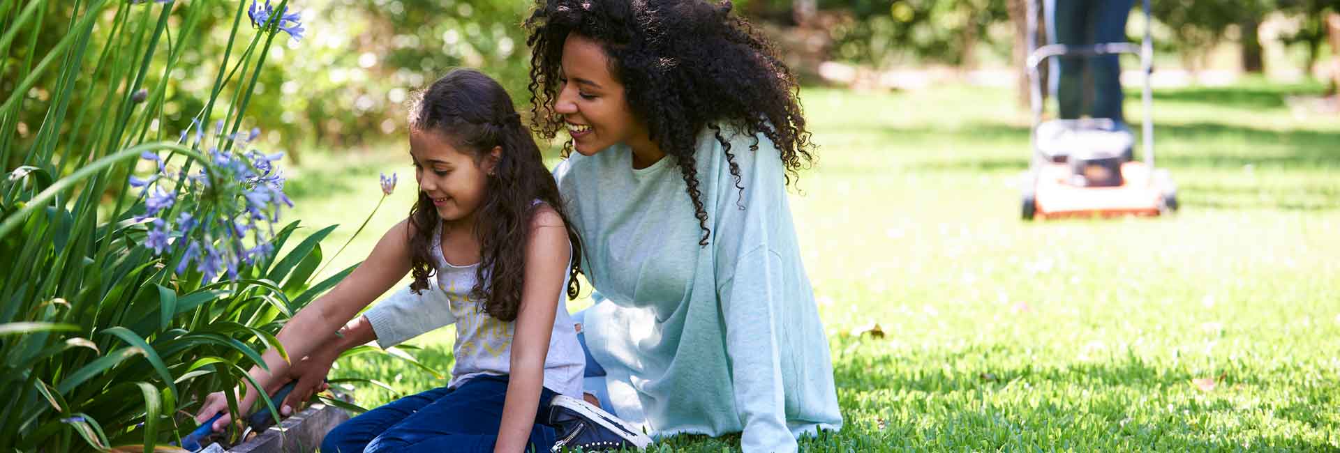 A mother and daughter enjoy time outside planting flowers