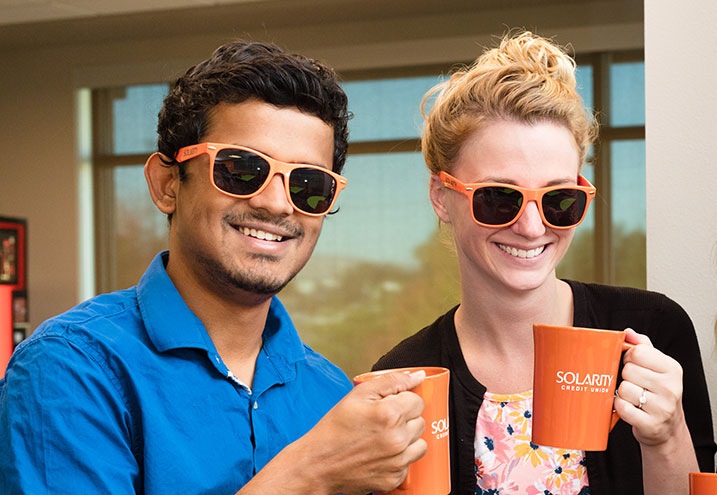 Two smiling Solarity Employees wearing Credit Union Merchandise