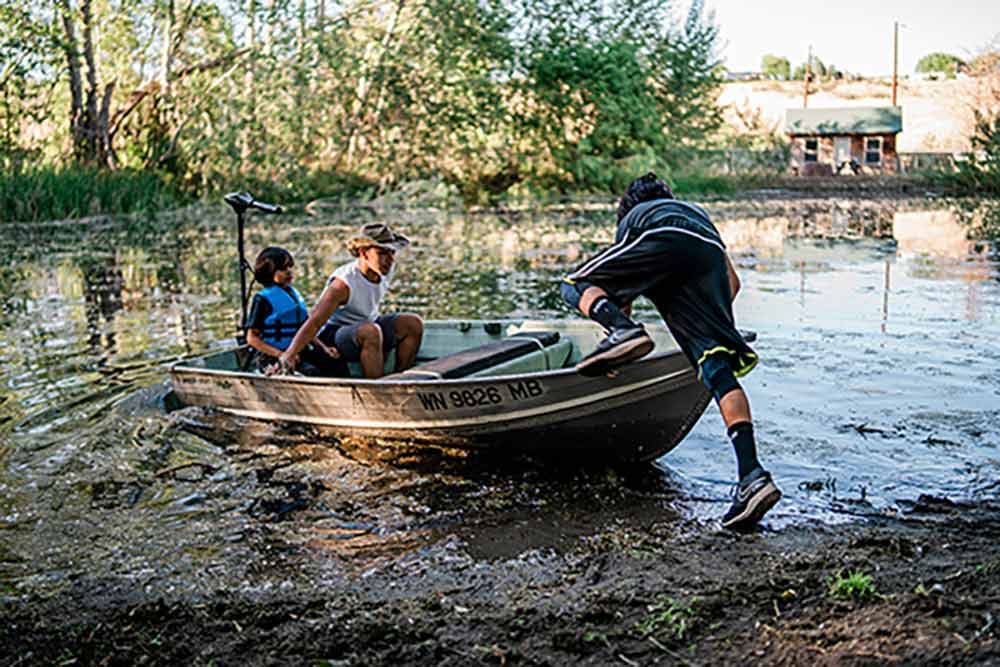 Gambito-bros_banner Three brothers pushing a boat off into a creek